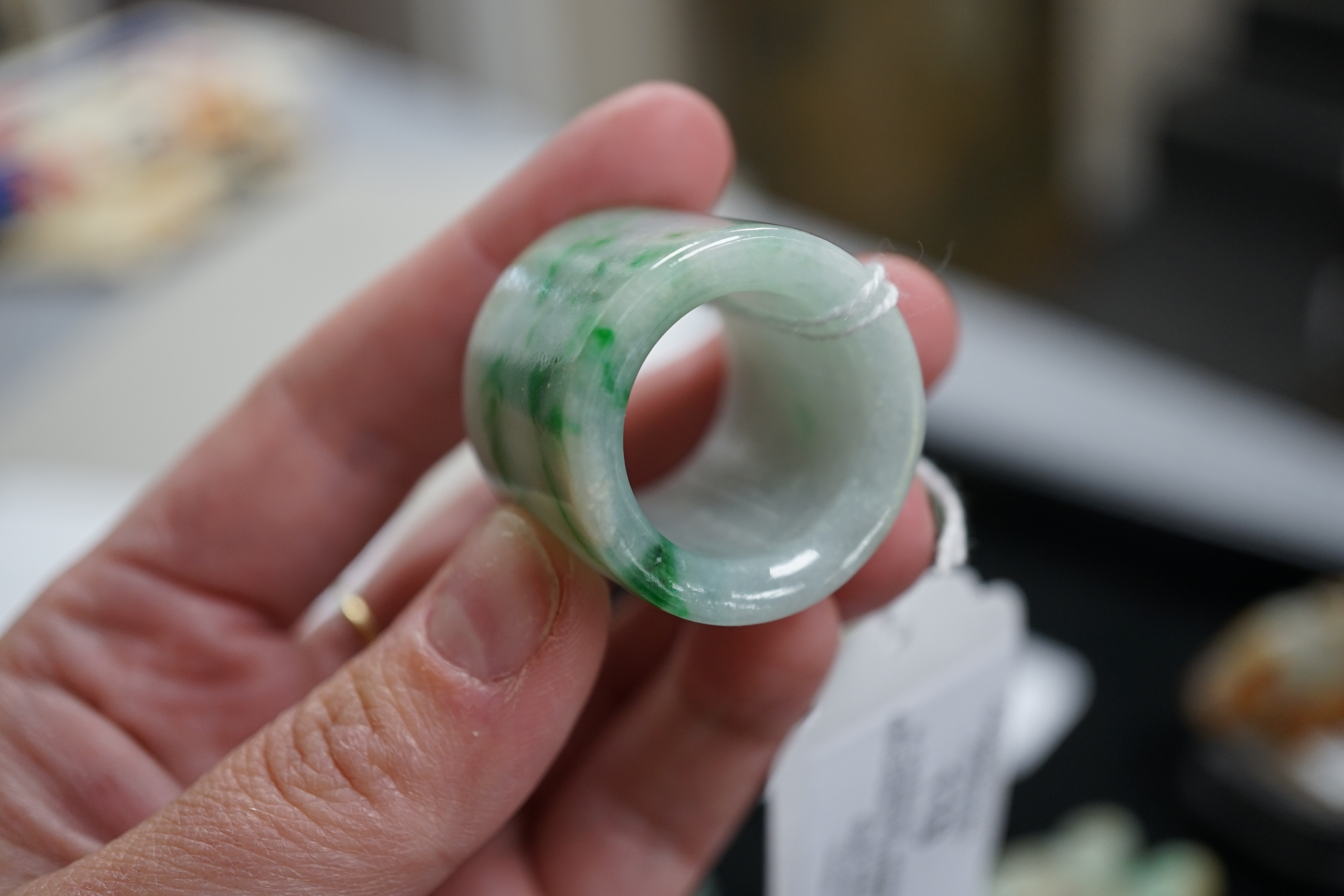 A Chinese jadeite archer's thumb ring, wood stand and cover, 19th century